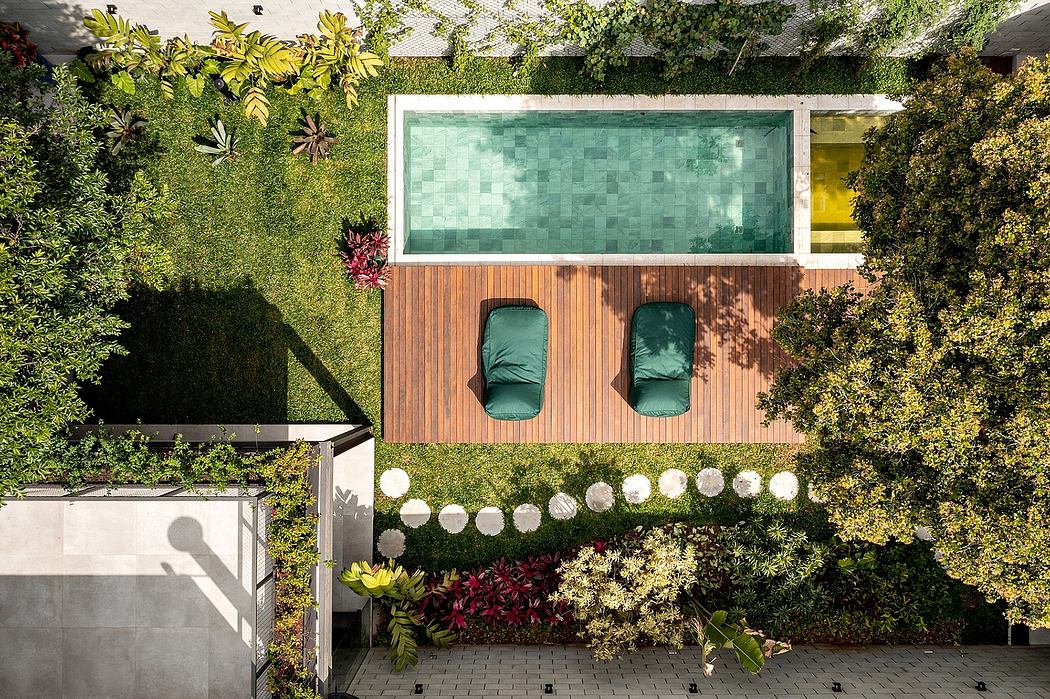 A modern outdoor space with a patio, pool, and lush greenery surrounding the setting.