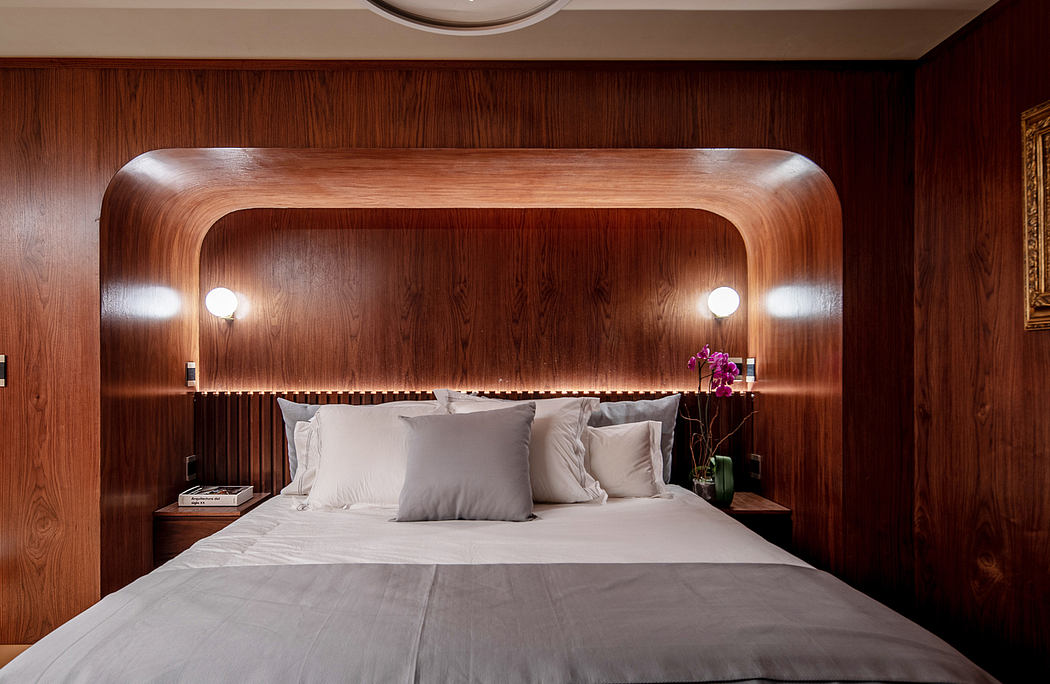 Wooden bed frame with recessed lighting and nightstands, complemented by a richly textured wall.