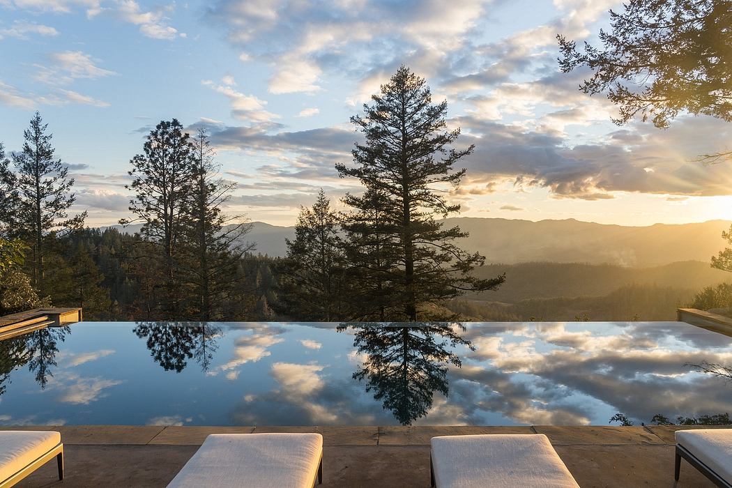 Stunning infinity pool with mountainous landscape and dramatic sky reflections.