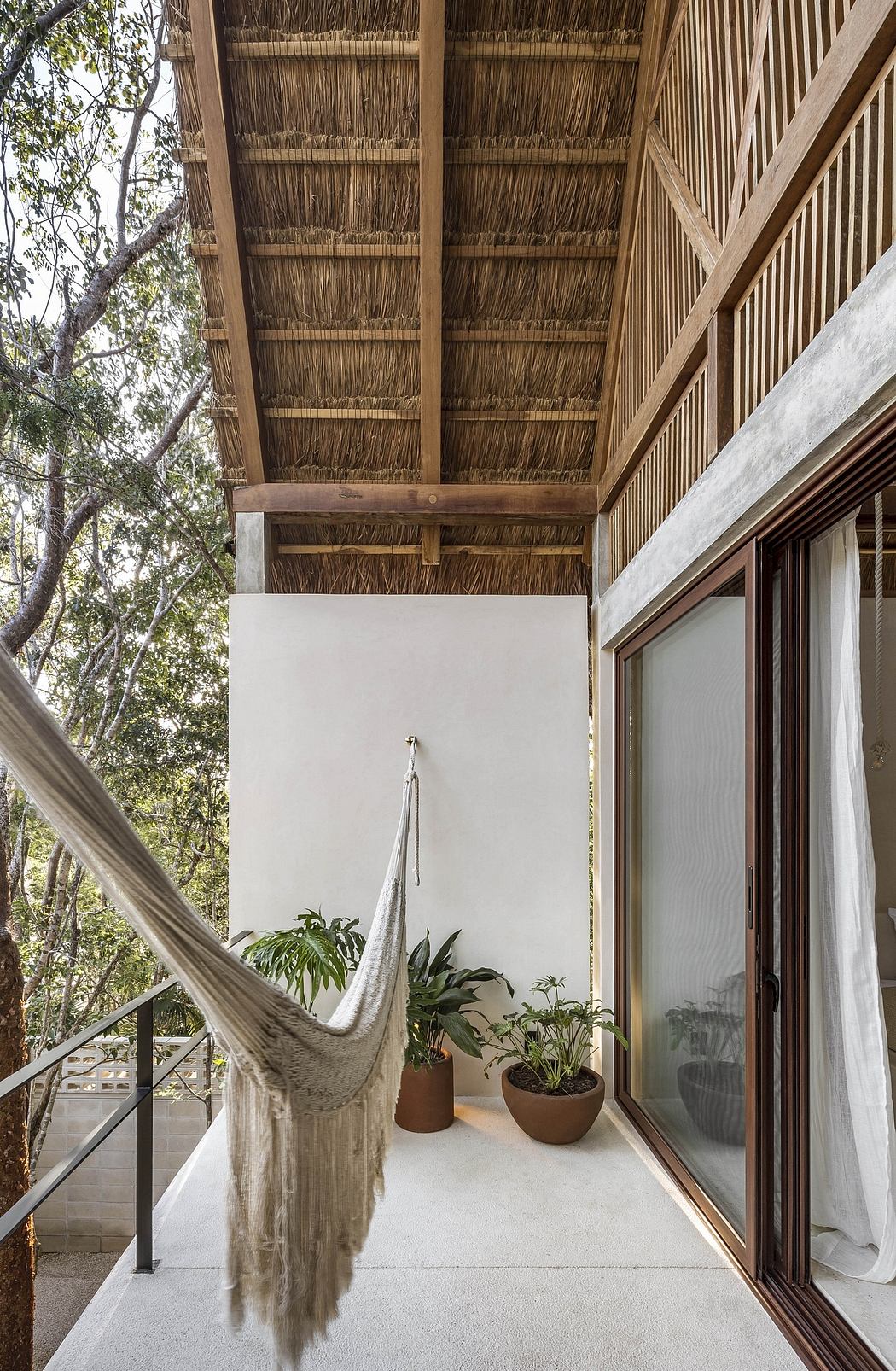 A cozy, rustic balcony with a thatched roof, hammock, and potted plants creating a serene, natural ambiance.