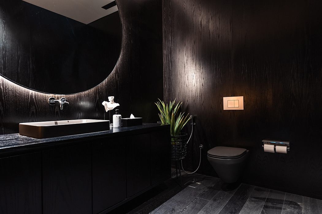 Sleek, modern bathroom with dark wood paneling, round mirror, and minimalist fixtures.