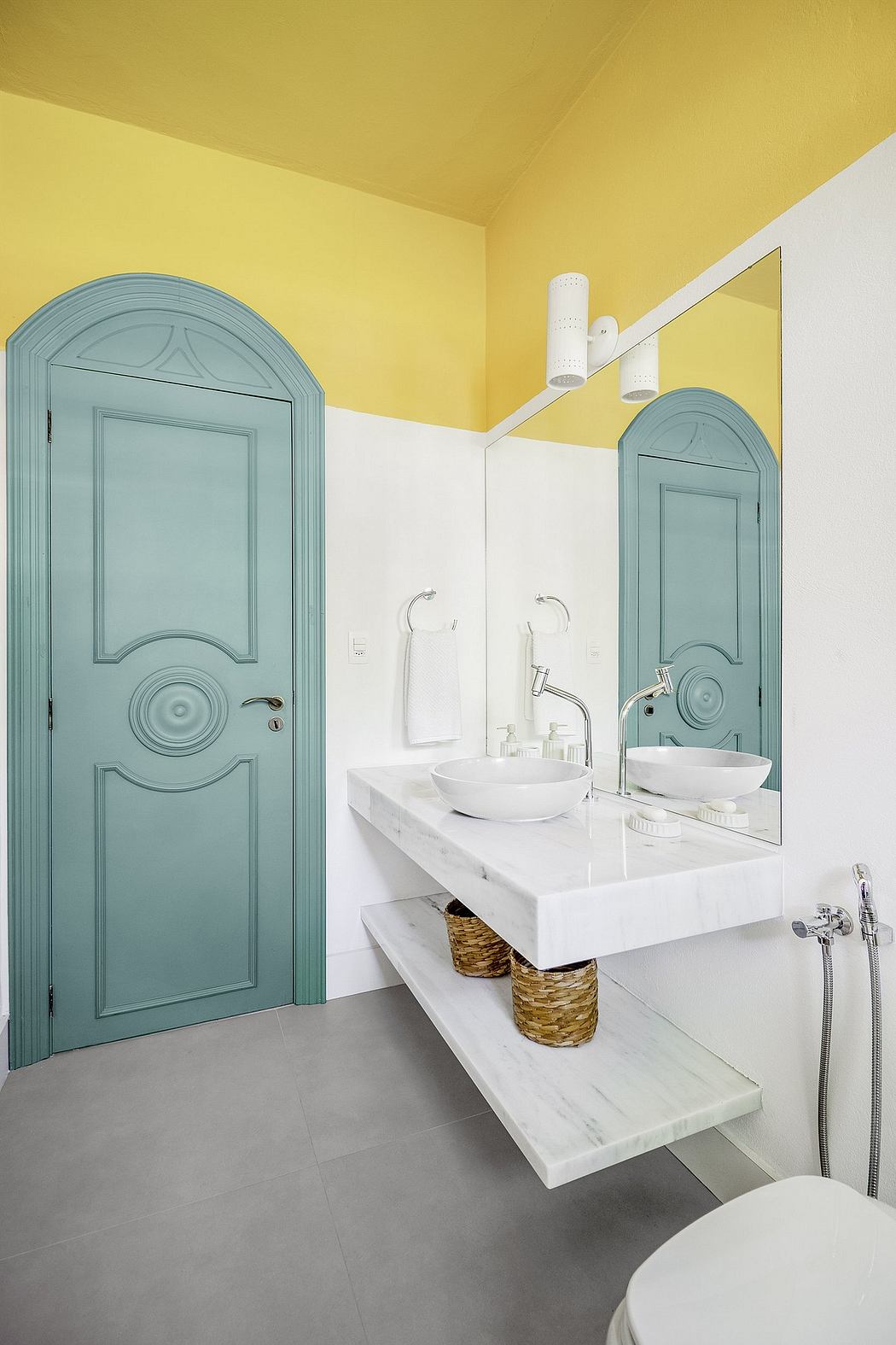 Bright, modern bathroom with mint-green arched doors, white vanity, and vessel sinks.
