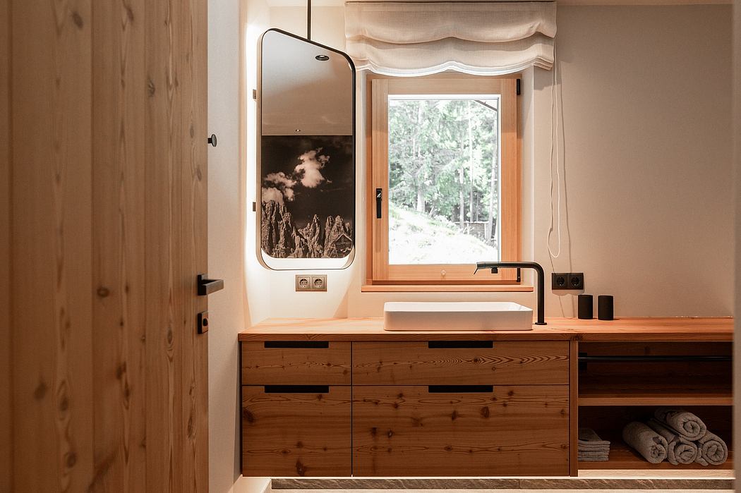 A rustic bathroom with wooden cabinetry, a rectangular mirror, and a scenic window view.