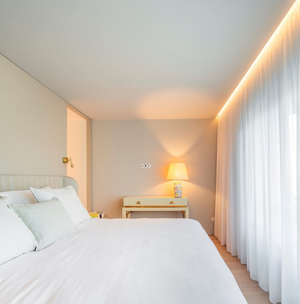 Elegant bedroom with minimalist decor, warm lighting, and floor-to-ceiling curtains.