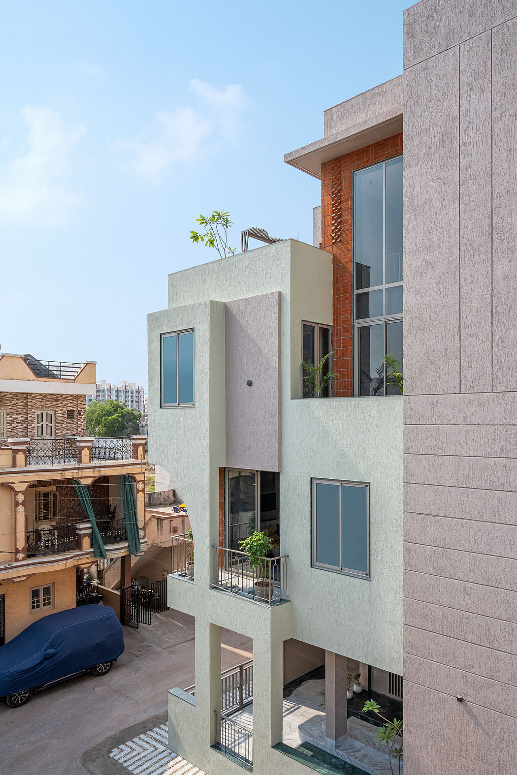 Modern multi-level building with geometric patterns, balconies, and diverse materials.