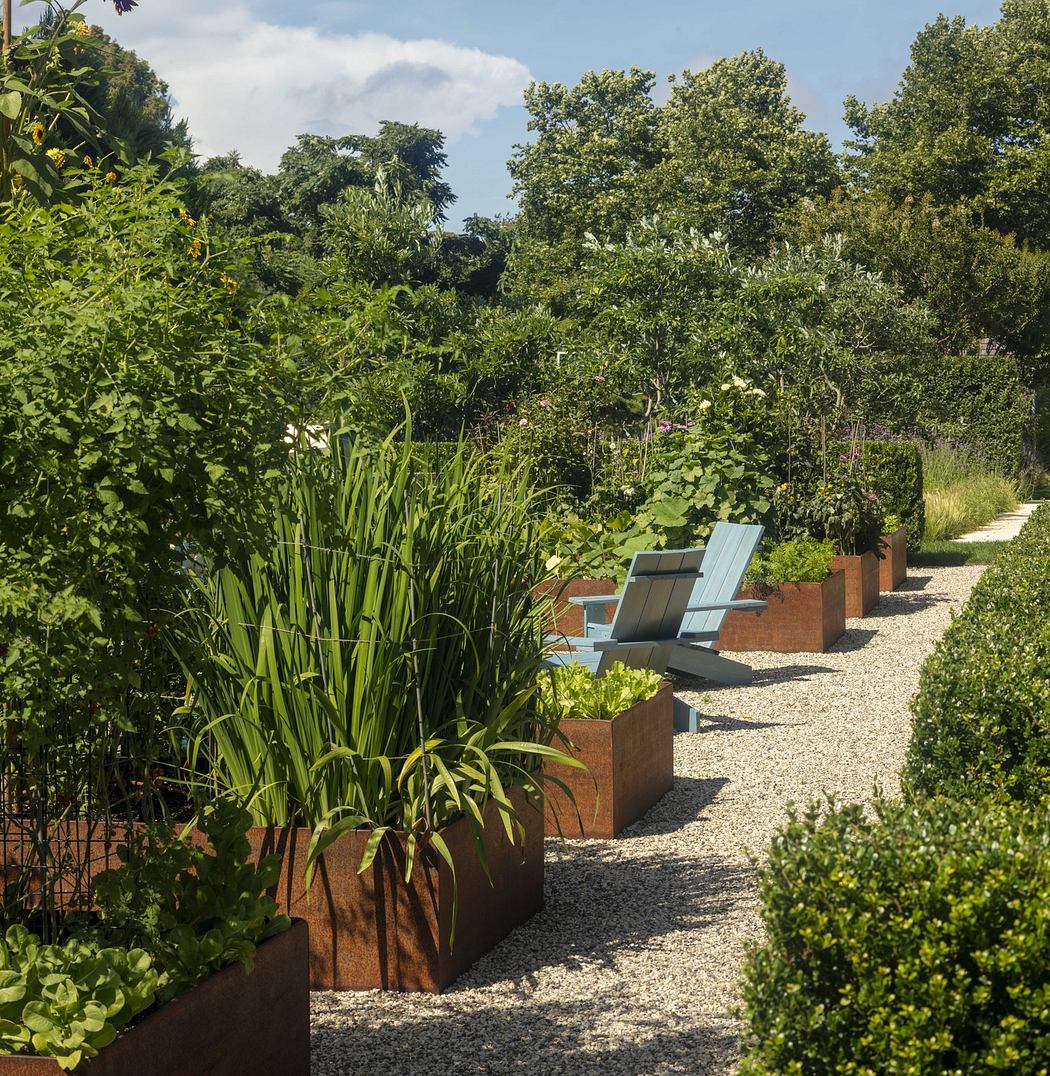 Lush, verdant garden path with modern planters and seating overlooking greenery.