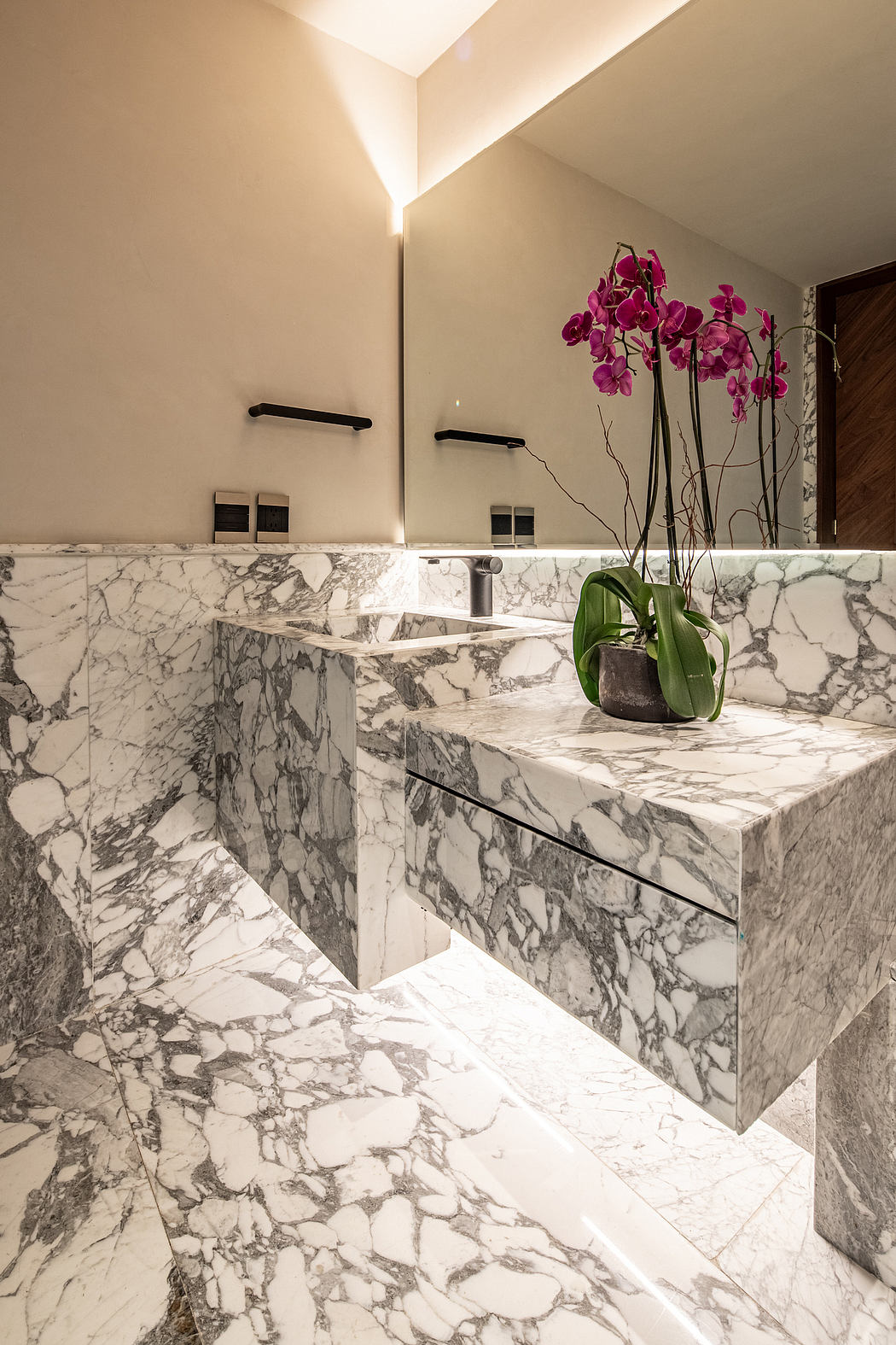 Luxurious bathroom with exquisite marble countertops, modern fixtures, and a vibrant orchid accent.