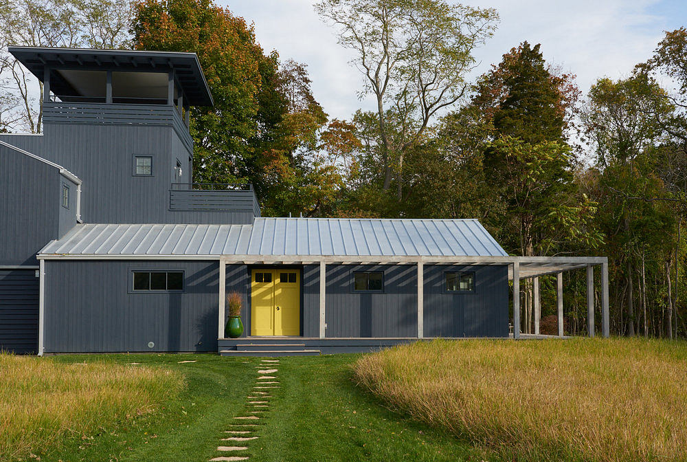 A modern, sustainable home nestled in a verdant forest, featuring striking architectural elements.