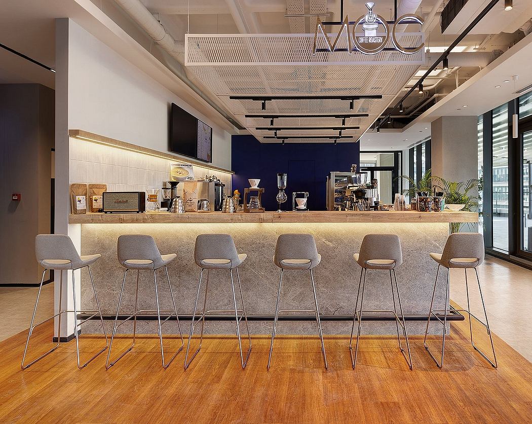 Modern cafe interior with sleek counter, hanging light fixtures, and wooden flooring.