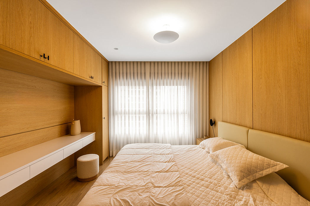 Warm, minimalist bedroom with built-in wooden cabinetry, soft lighting, and cozy bed.