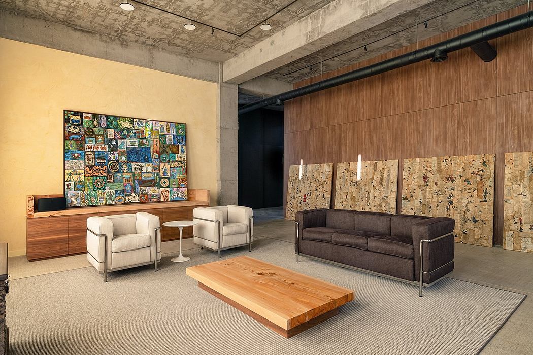 A modern, urban lounge with exposed concrete, wooden accents, and eclectic artwork.