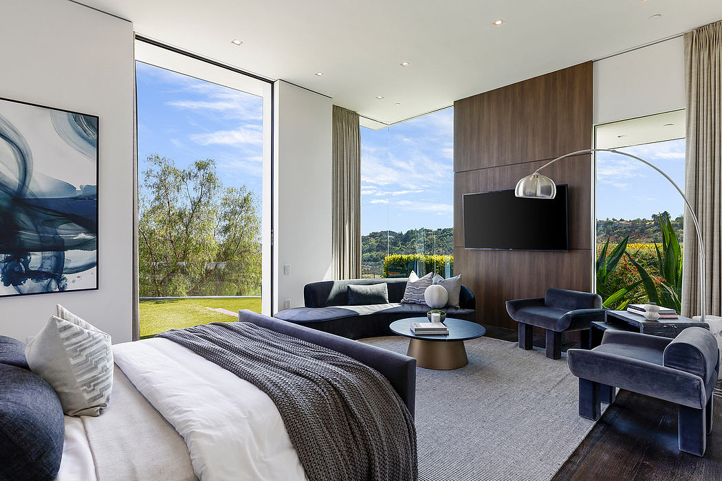 Spacious bedroom with floor-to-ceiling windows, plush furniture, and a contemporary design.