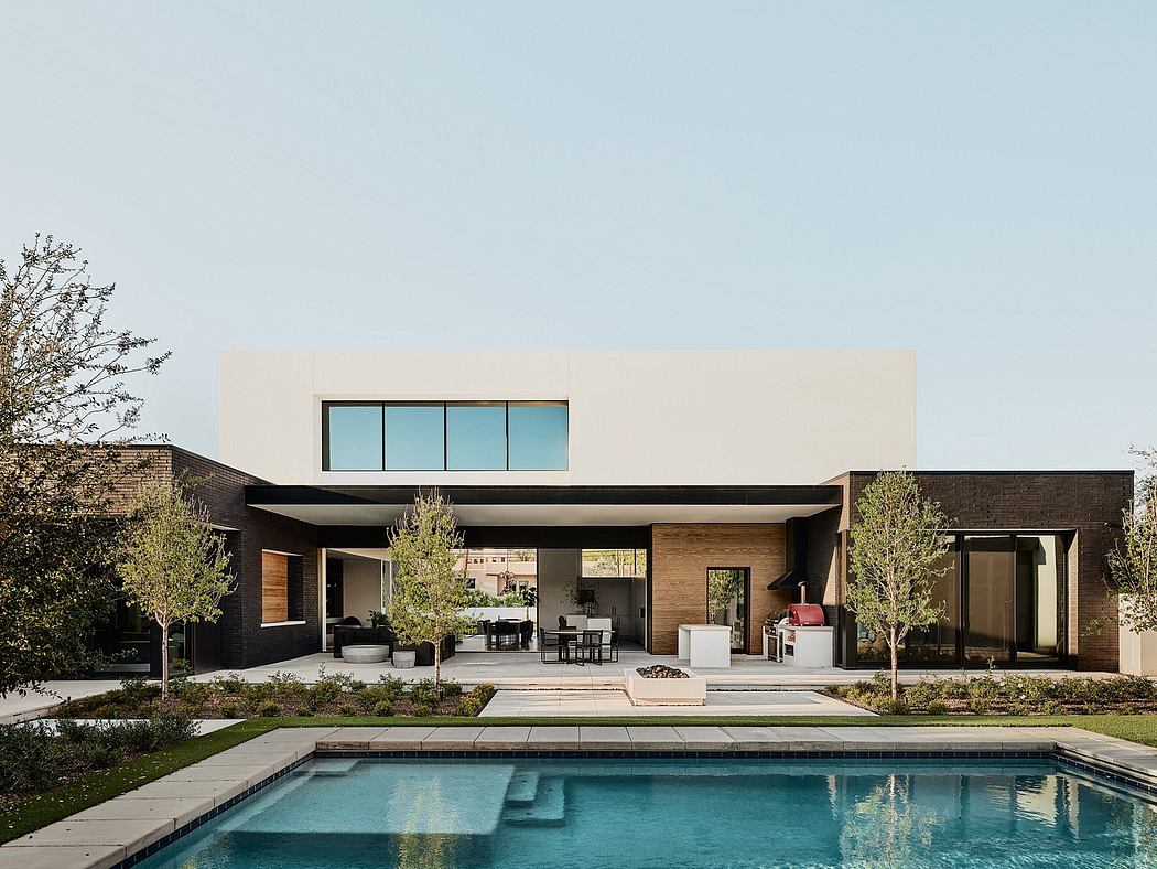 Modern home with clean lines, large windows, and a pool reflecting the exterior.
