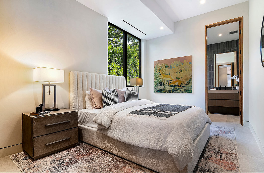 Cozy, modern bedroom with large windows, plush bedding, and vibrant artwork.