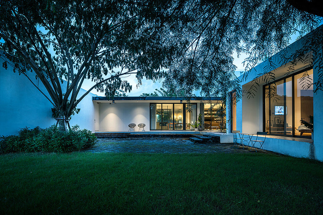 A modern one-story house with an open floor plan, surrounded by lush greenery and a small pool.