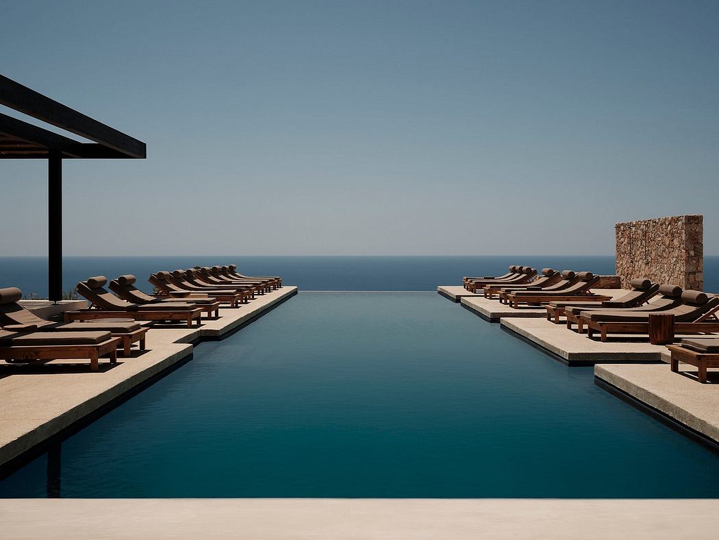 A scenic infinity pool with a tiered wooden deck and a clear view of the distant ocean.