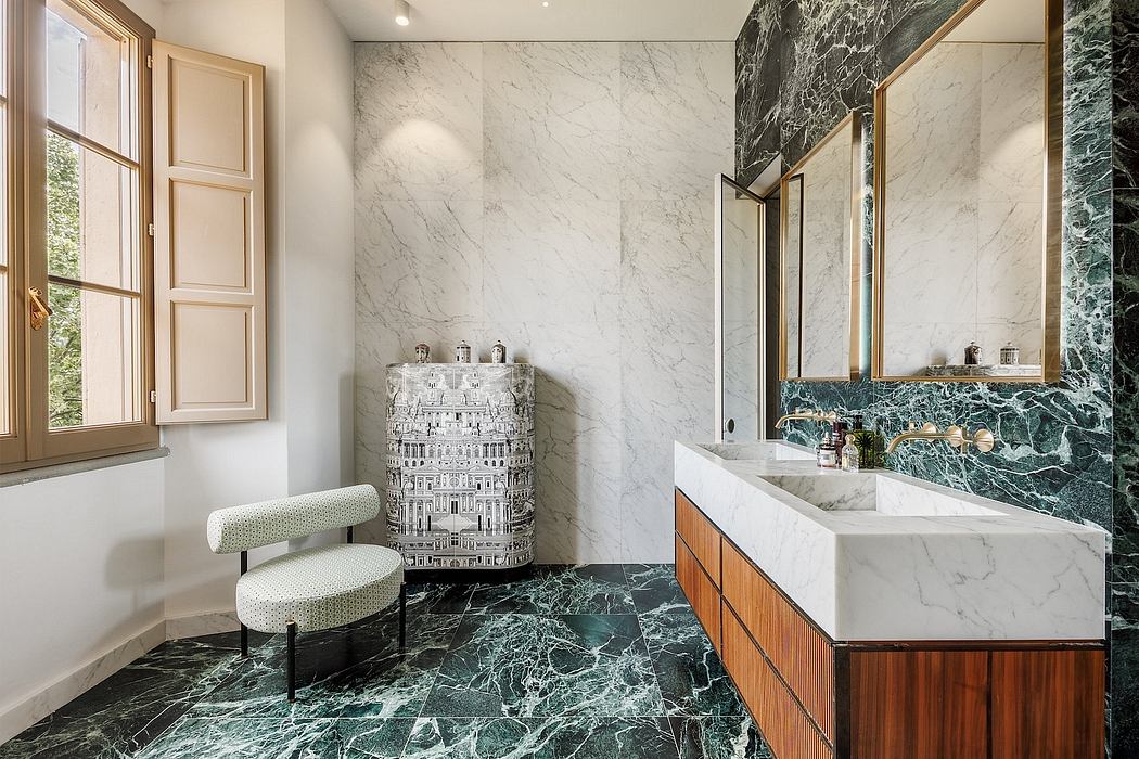 This luxurious bathroom features a marble vanity, patterned tile floors, and a freestanding chair.