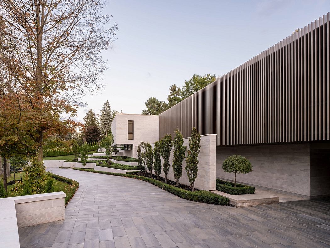 A modern, minimalist building with clean lines, landscaped gardens, and paved walkways.