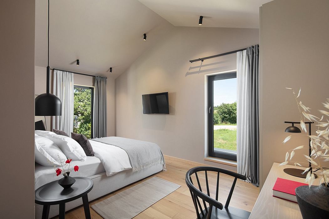 Spacious bedroom with modern furnishings, large window overlooking a grassy field.