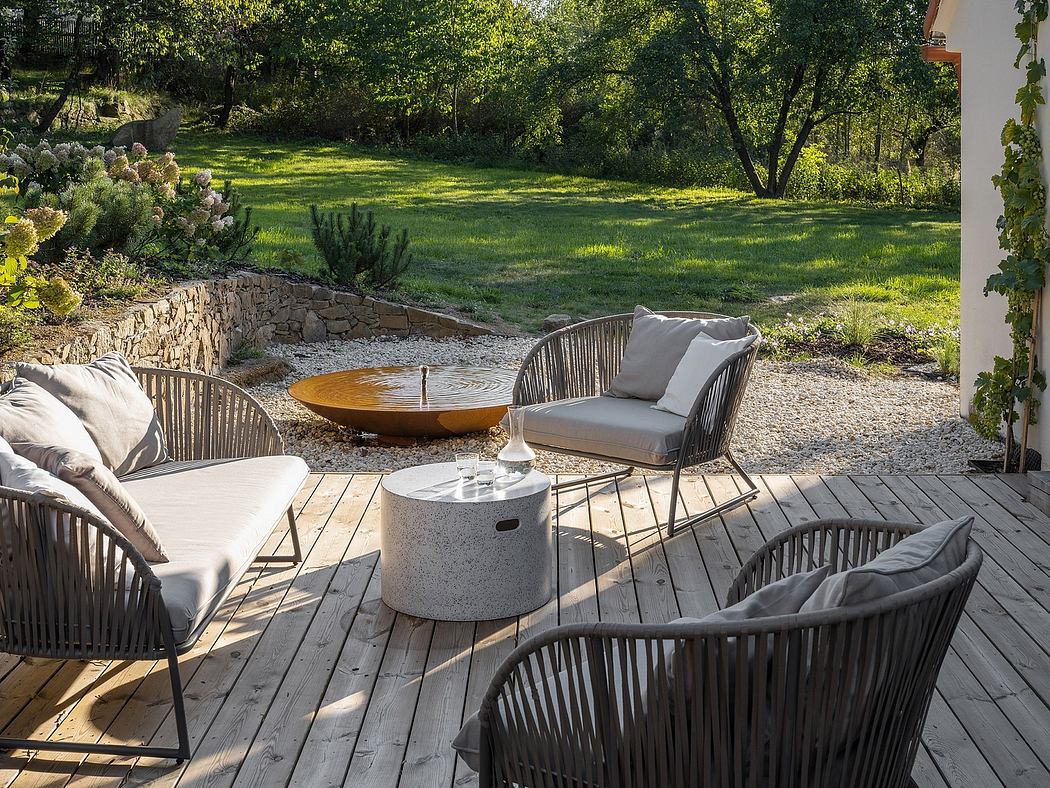 Tranquil garden oasis with wooden deck, plush seating, and reflective water feature.
