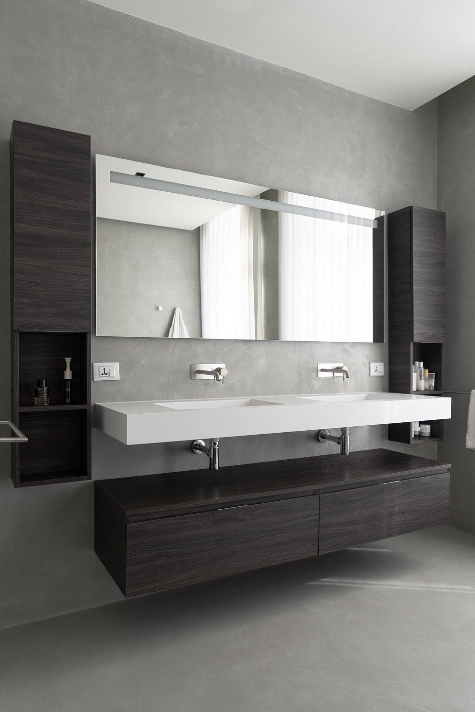 A modern, minimalist bathroom design with a large mirror, floating vanity, and clean lines.