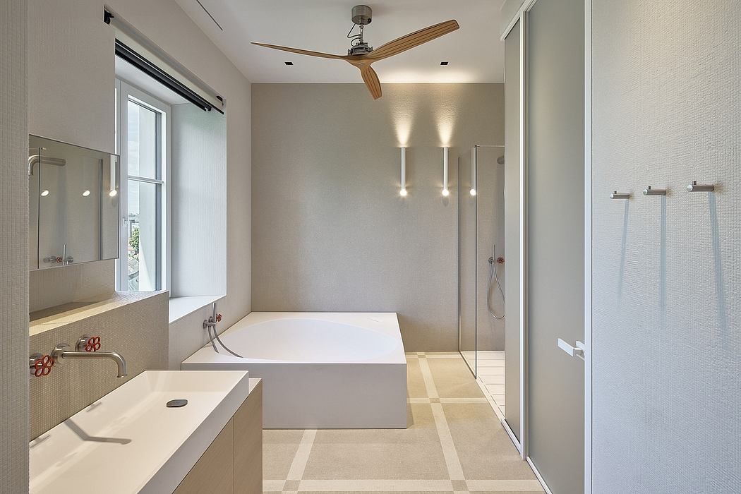 Minimalist bathroom with modern freestanding tub, rain shower, and wood-accented ceiling fan.