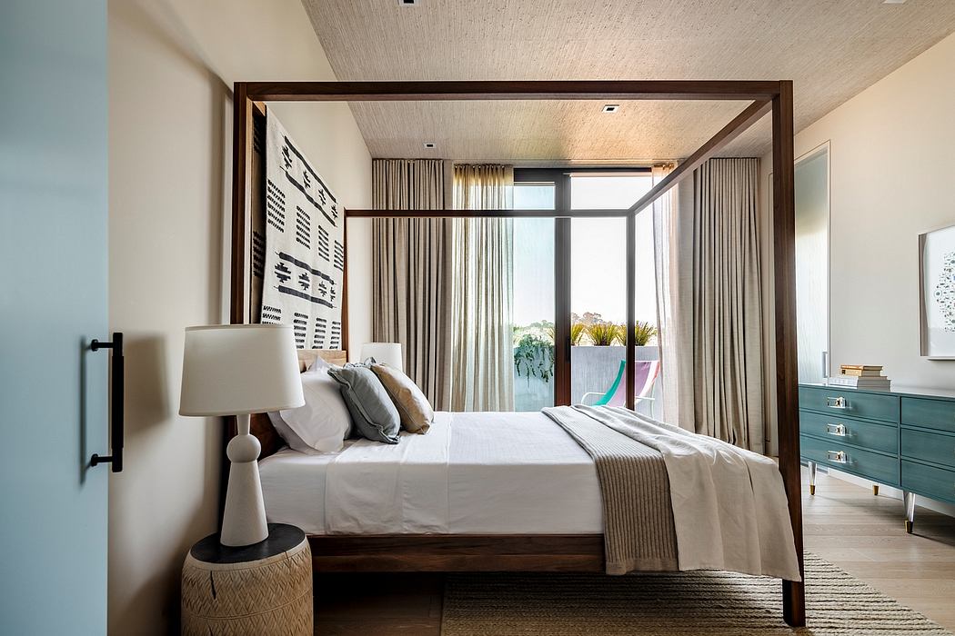 Spacious bedroom with modern wooden furnishings, large windows, and a canopy bed.