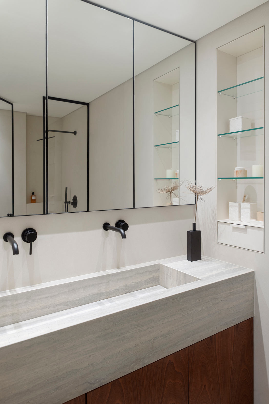 Contemporary bathroom with a minimalist, sleek design featuring a large mirror, floating marble vanity, and black fixtures.