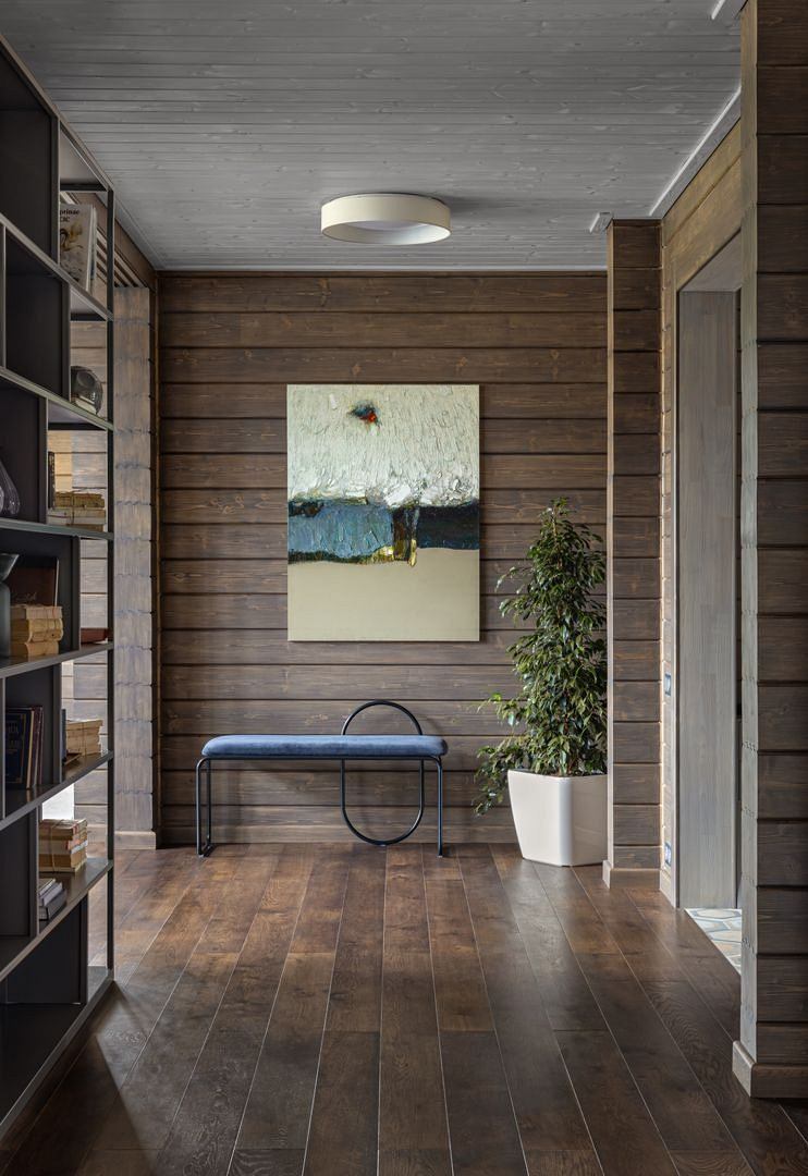 Rustic wood-paneled room with minimalist decor, artwork, and wooden floor. Cozy yet modern aesthetic.