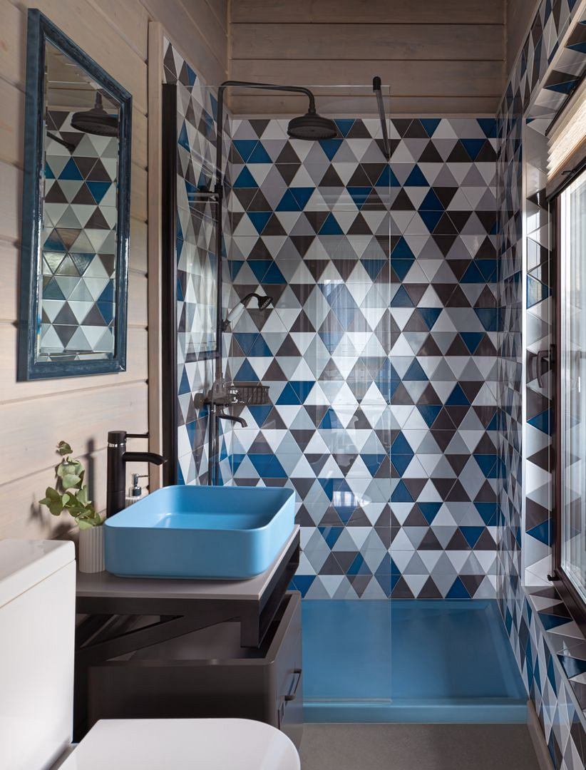 Striking geometric patterns adorn the bathroom walls, complemented by sleek modern fixtures.