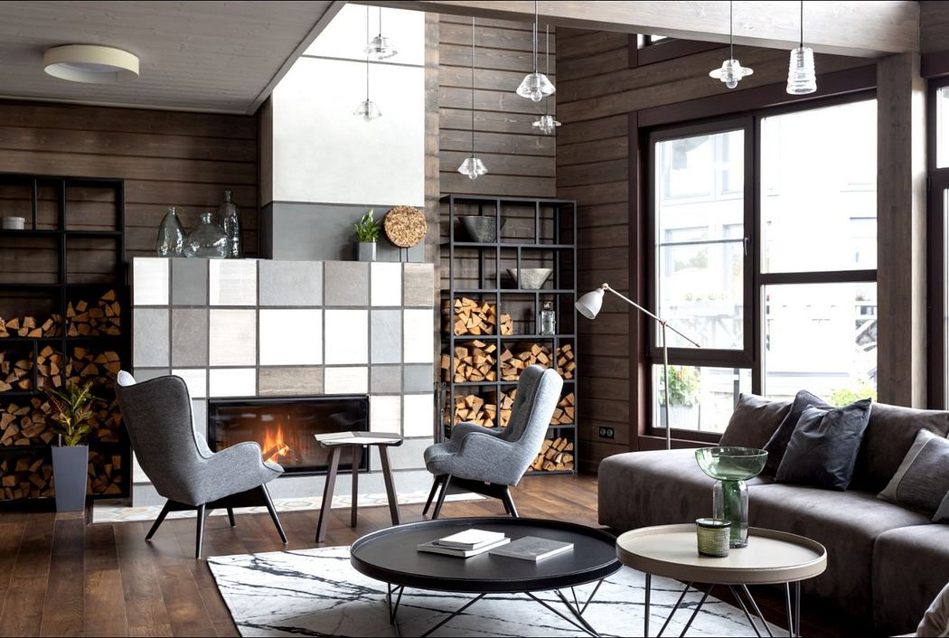 Rustic wood-paneled walls, modern fireplace, and stylish furniture create a cozy, inviting space.