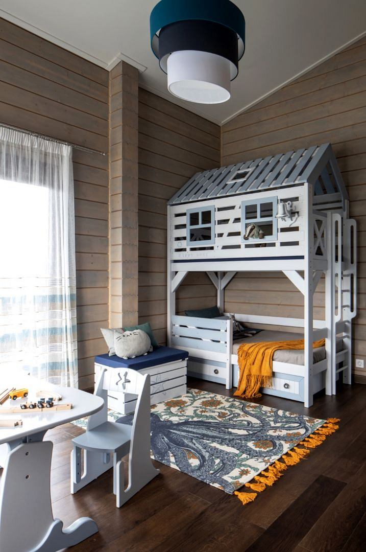 Cozy wood-paneled room with a playful lofted bed, area rug, and minimalist furnishings.