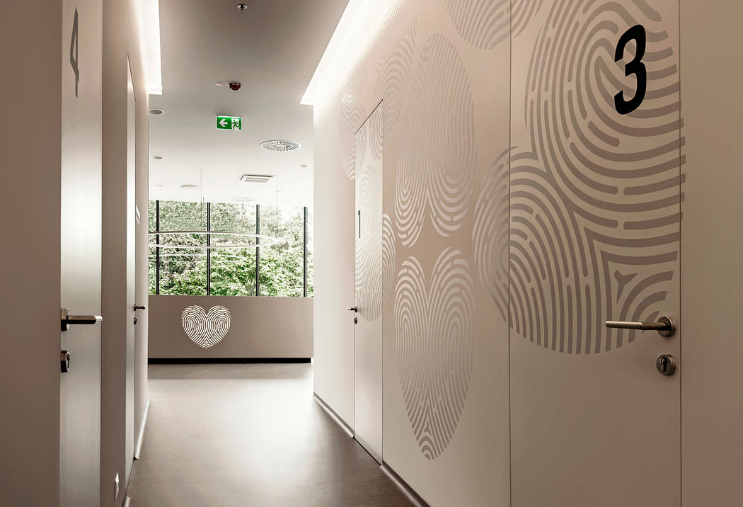 A modern, minimalist hallway with geometric patterns on the walls and large windows overlooking greenery.