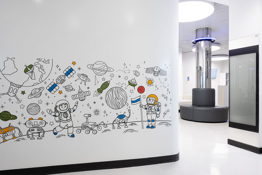 Sleek, modern interior with colorful, space-themed mural and cylindrical lighting feature.