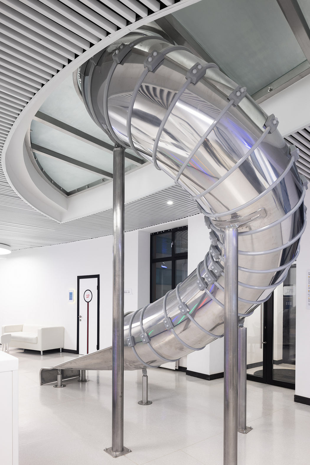 Sleek spiral staircase with metallic accents and modern, minimalist interior design.