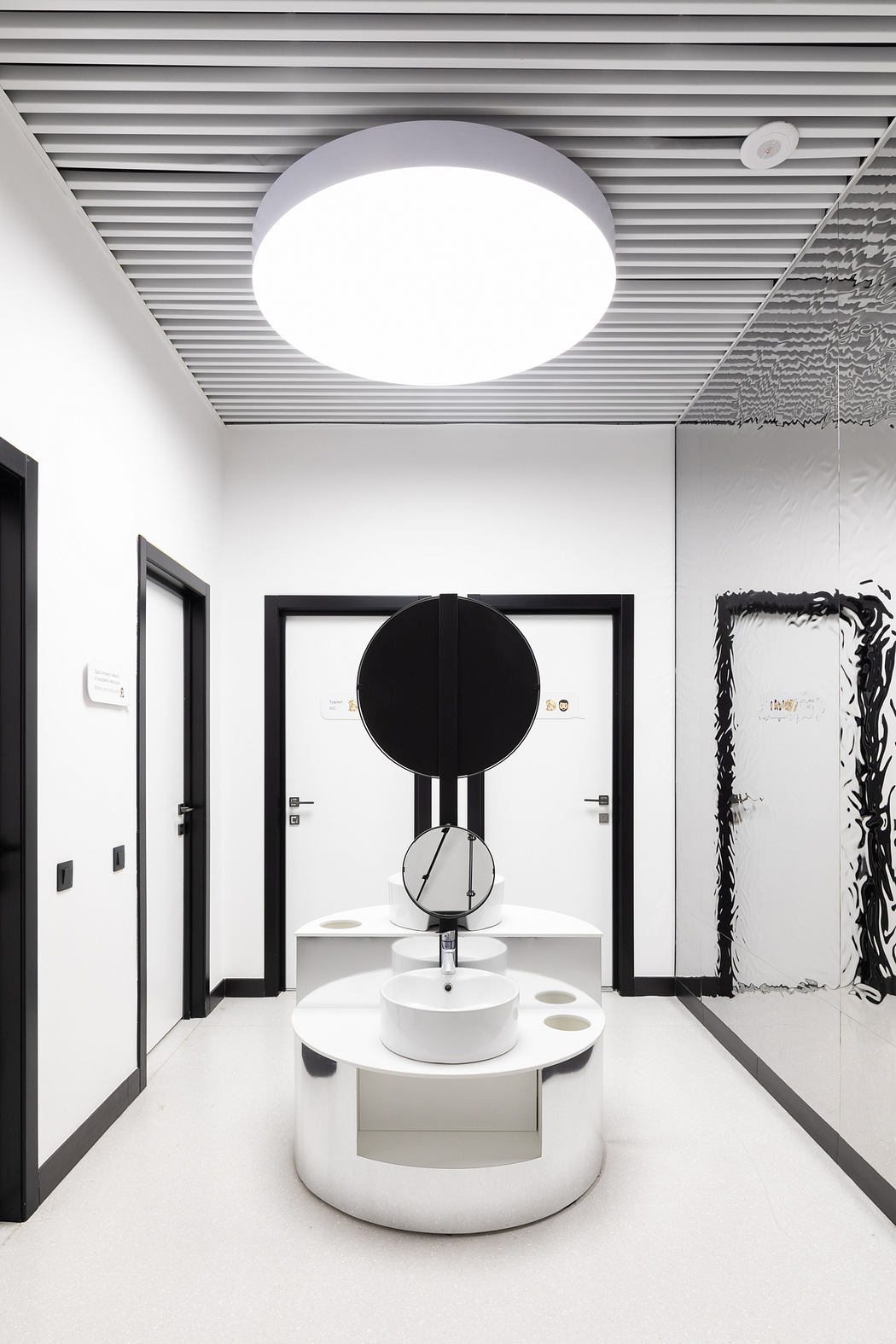 Minimalist bathroom design with circular vanity mirror and pendant lighting.