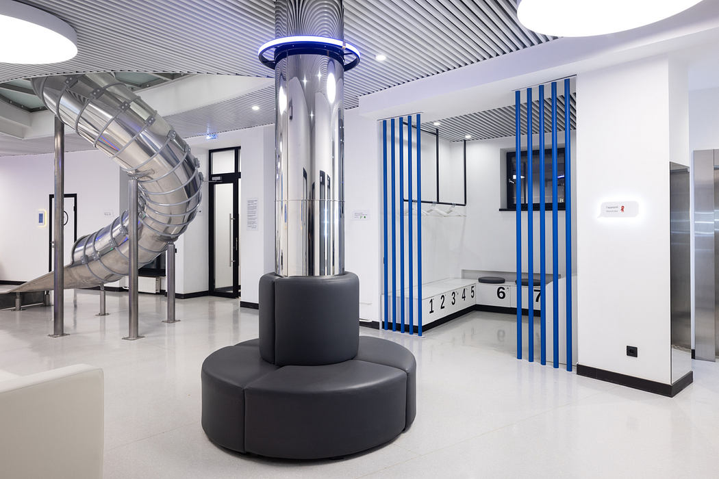 A sleek, modern interior with curved architectural features, blue accents, and minimalist furniture.