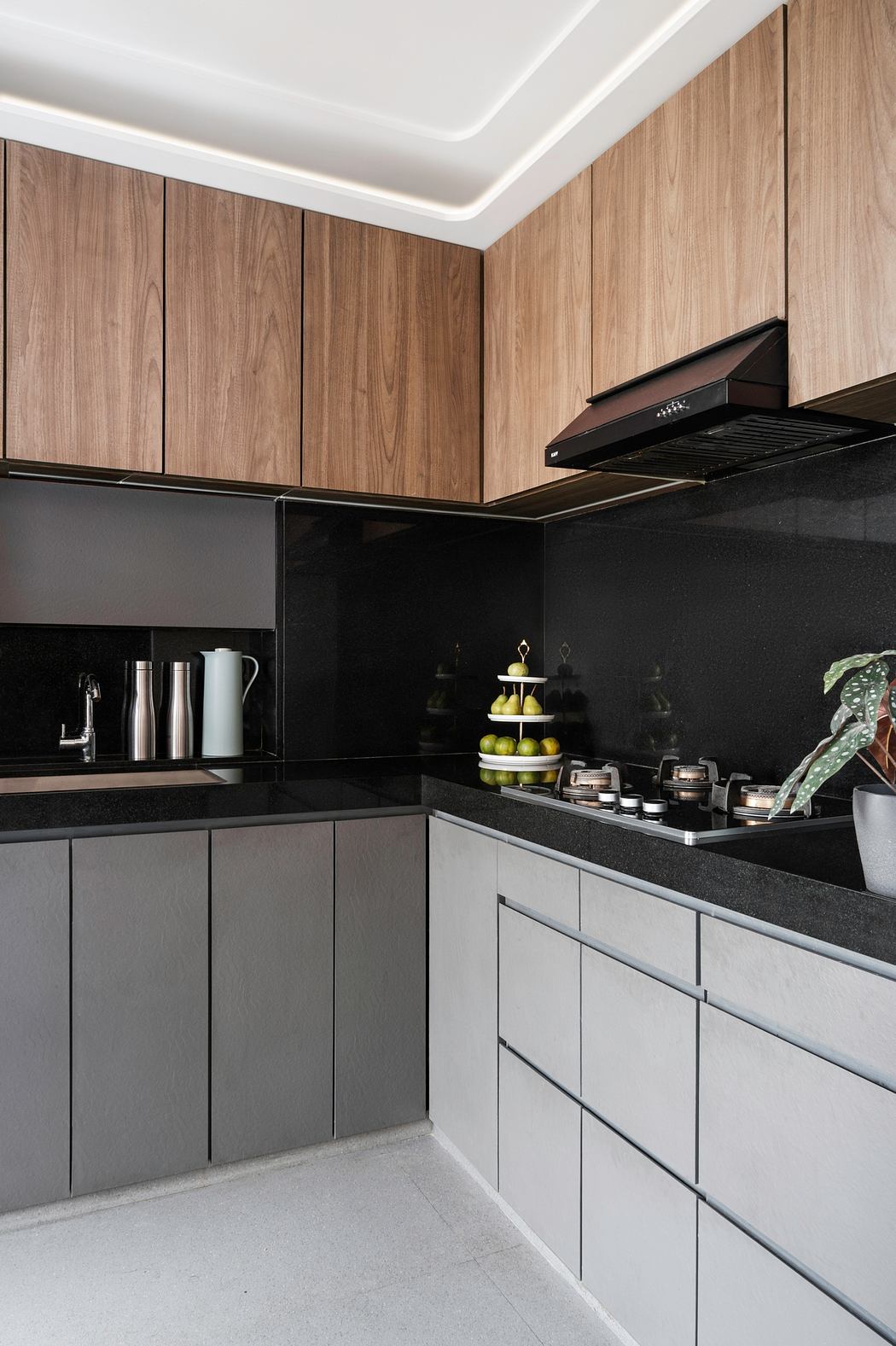 A modern kitchen with sleek wood cabinets, black countertops, and built-in appliances.