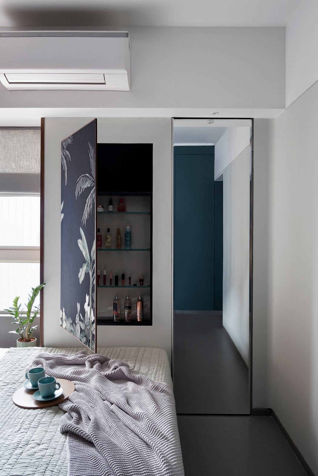 A modern bedroom with a built-in storage cabinet, minimalist decor, and a cozy bed.
