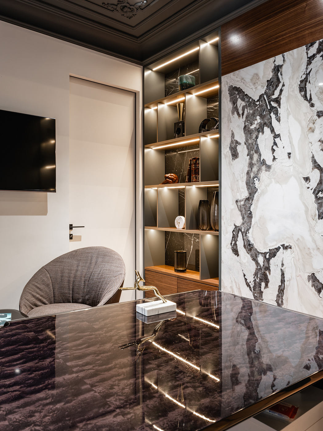 Luxurious modern interior with ornate ceiling, marble walls, and recessed lighting.