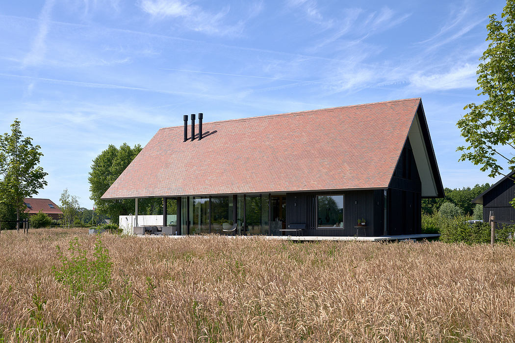 Modern farmhouse-style home with a prominent gabled roof and large glass windows.