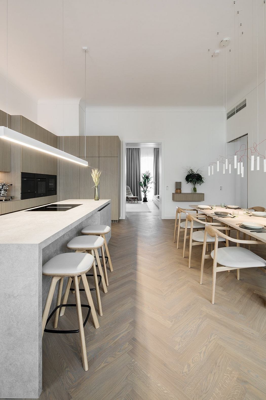 Sleek, modern kitchen with bar seating and dining area; neutral tones and clean lines.