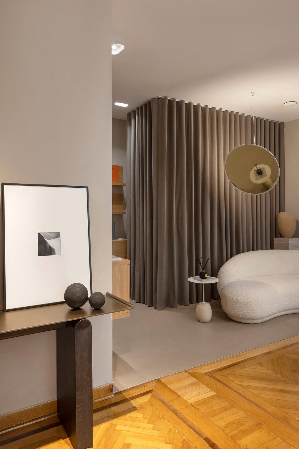 Minimalist bedroom with geometric artwork, curtain divider, and wooden furniture.