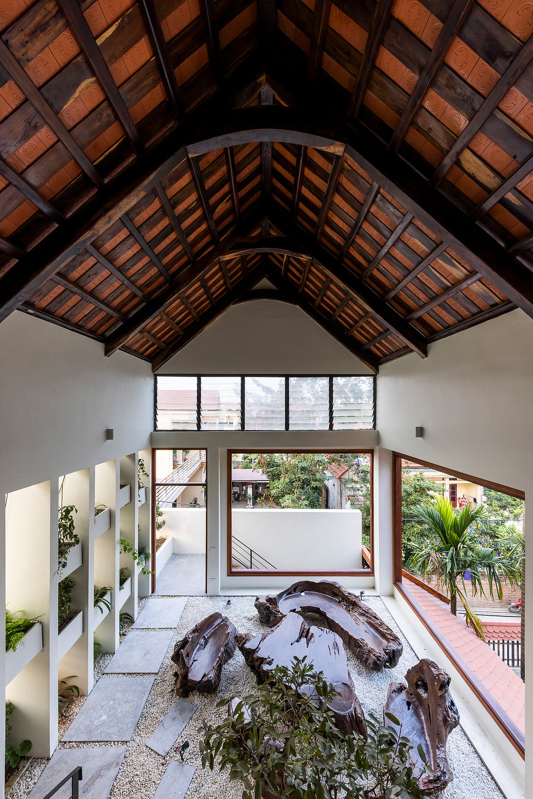 Ornate wooden ceiling, natural stone features, and lush indoor greenery create a harmonious ambiance.