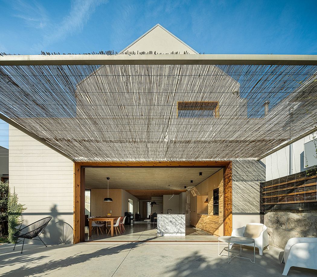 A modern design with a wooden structure, shaded patio, and marble kitchen countertop.
