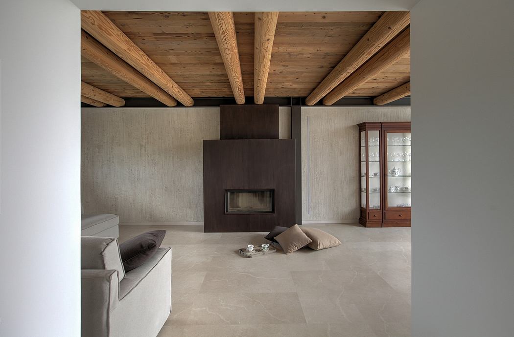 Rustic wooden ceiling beams, sleek fireplace, and minimalist decor create a cozy ambiance.