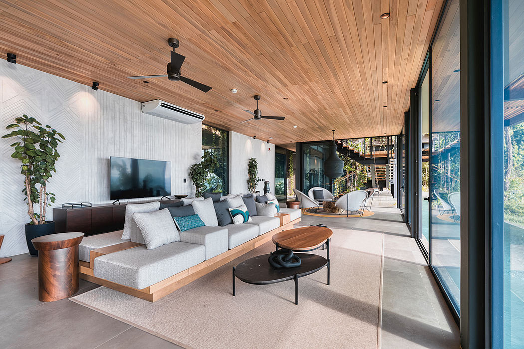 Large modern living room with wooden ceiling, glass walls, and minimalist furniture.