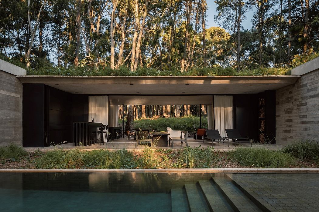 A modern, open-concept home with large windows overlooking a lush, forested landscape.