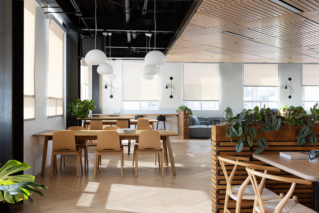 Airy, modern workspace with wooden furniture, greenery, and sleek lighting fixtures.