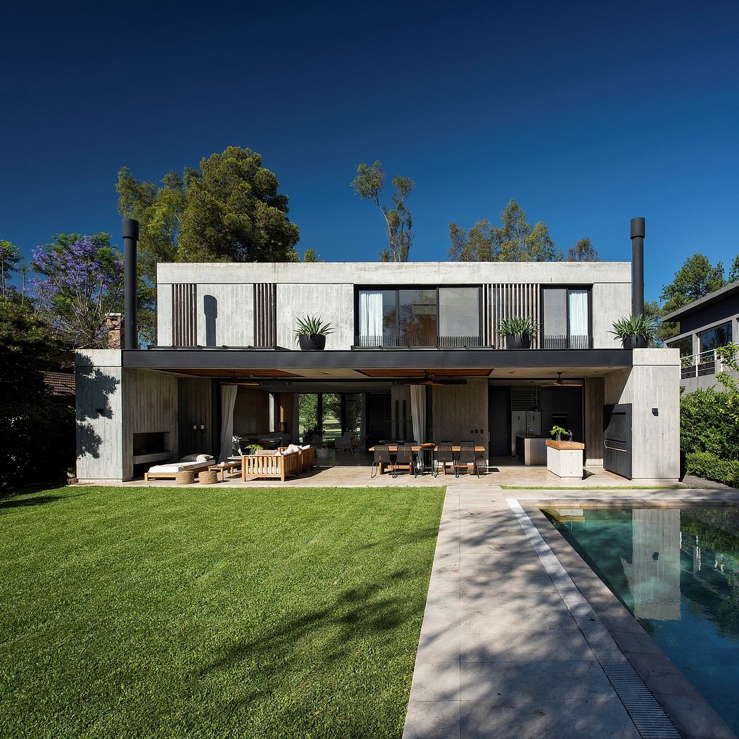 A modern, minimalist house with a large, open-plan living area, pool, and lush landscaping.